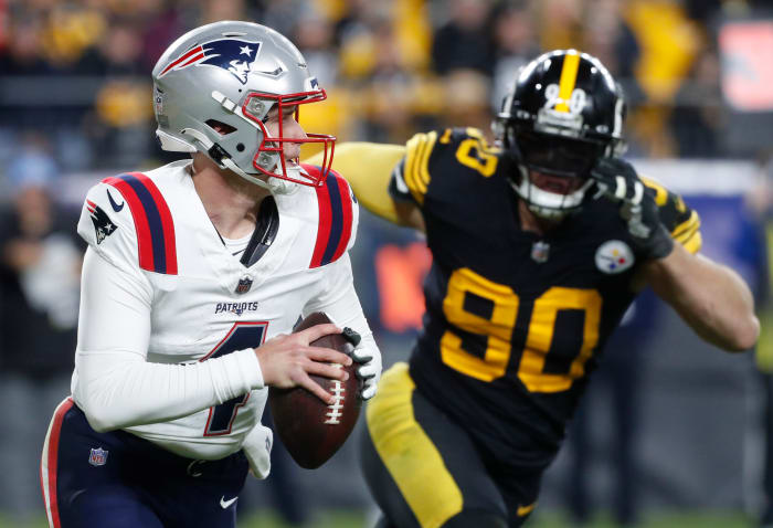 New England Patriots quarterback Bailey Zappe (4) runs the ball as Pittsburgh Steelers linebacker T.J. Watt (90) chases during the third quarter at Acrisure Stadium. New England won 21-18.